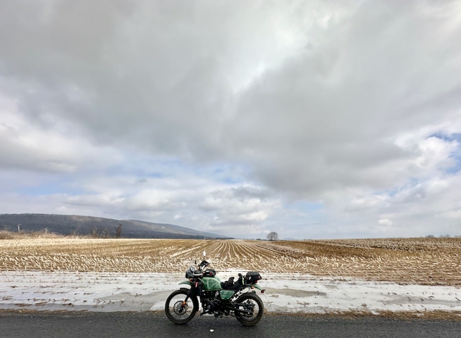 2022 Royal Enfield Himalayan Motorcycle s'est garé le long d'un terrain de ferme en hiver.