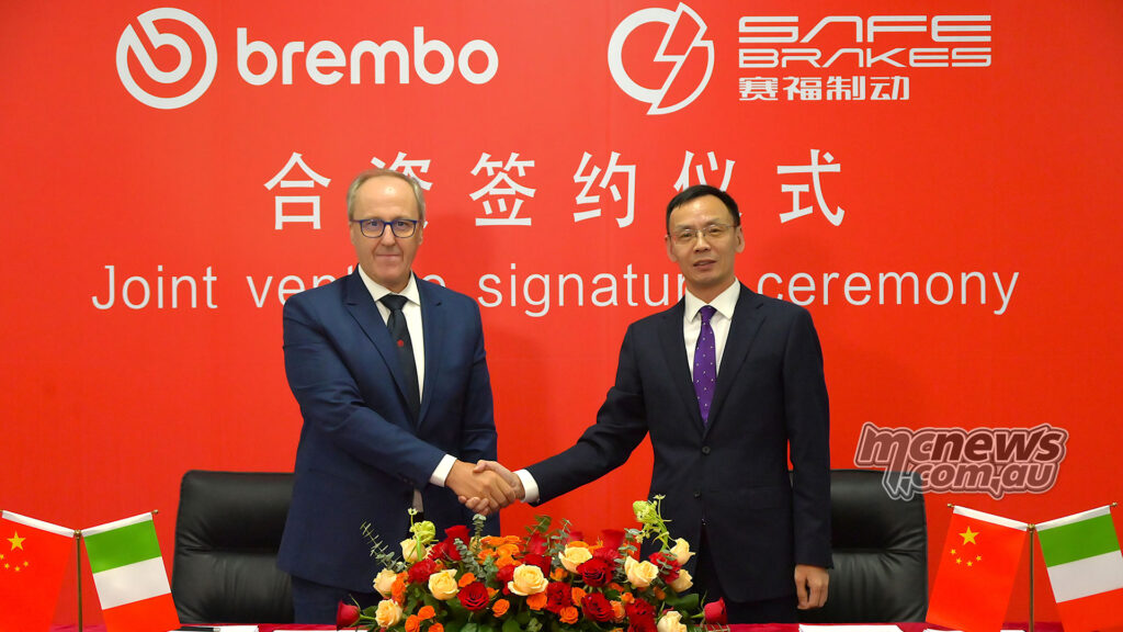 Les représentants de Brembo et Ningbo SAFE Brakes Systems se serrent la main lors de la cérémonie de signature d'une nouvelle coentreprise indienne pour l'ABS pour motos.