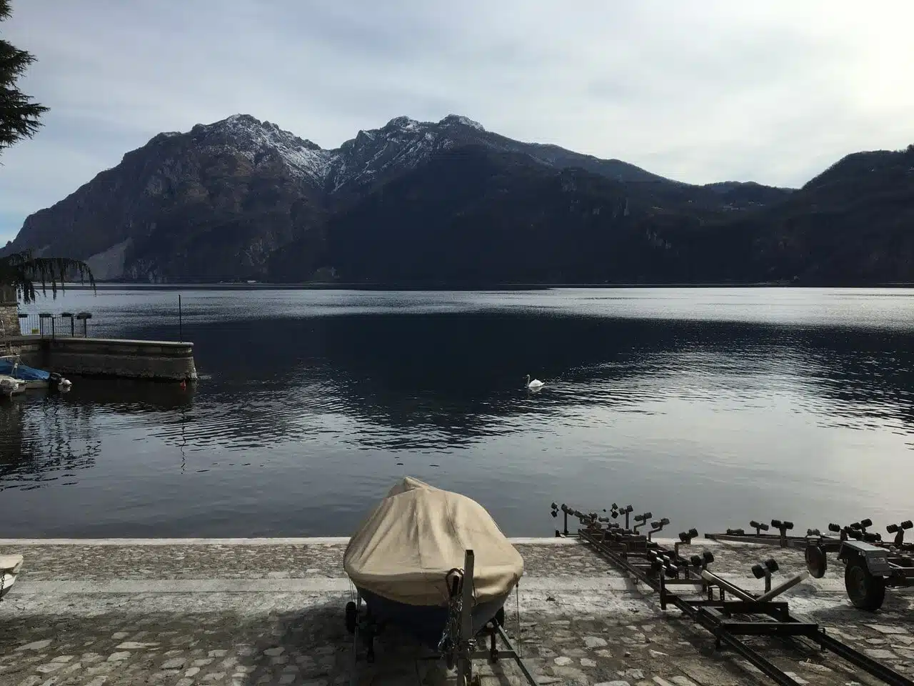 Rive du lac de Côme à Mandello del Lario, bateaux sur remorques et montagnes en arrière-plan
